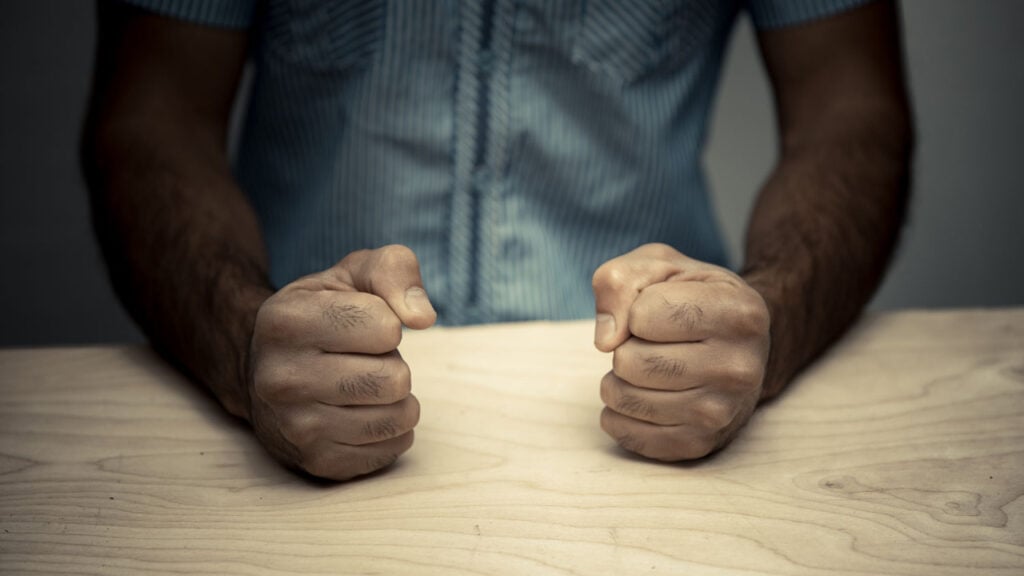 What is Narcissistic Injury? 1 a man forming two fists on a table