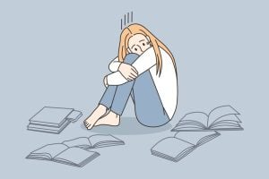Illustration of an anxious student surrounded by open text books.