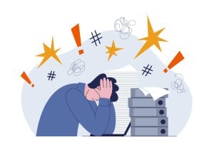 Illustration of a stressed worker at a desk with piles of paper and folders.