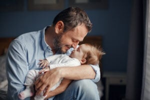 A father embracing his newborn baby.