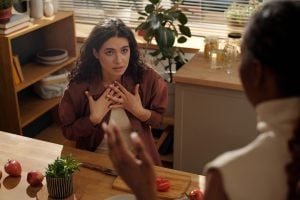 Two women having a disagreement with one blaming the other.