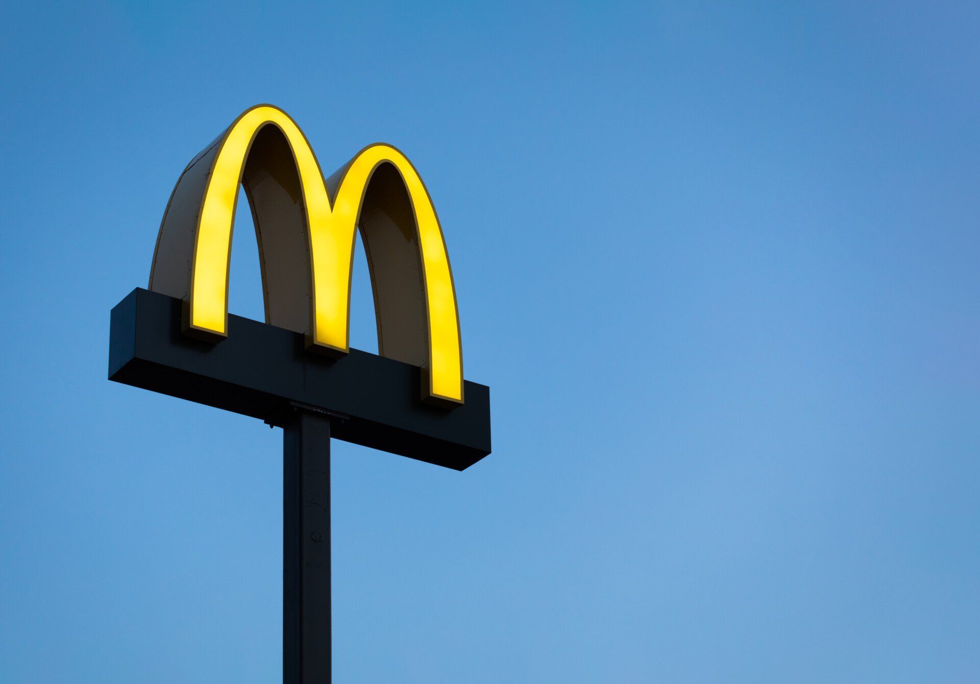 View of the M McDonald's sign against a blue sky