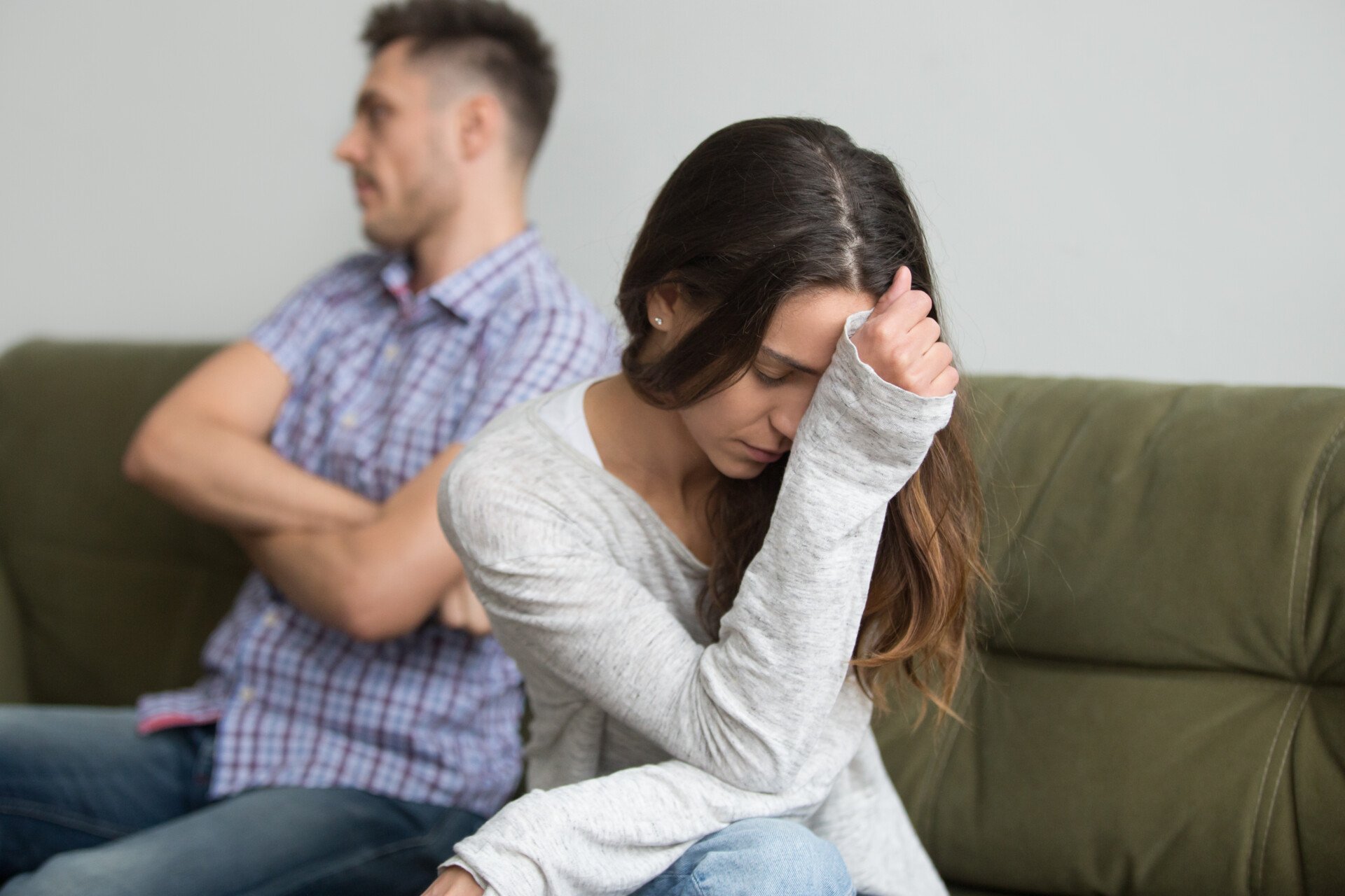 Relationship Ambivalence A frustrated couple facing away from each other, man has arms crossed, woman has head in hand.